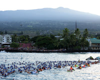 Wasserstart beim Ironman Hawaii. Athleten in blauer Badekappe warten auf den Startschuss