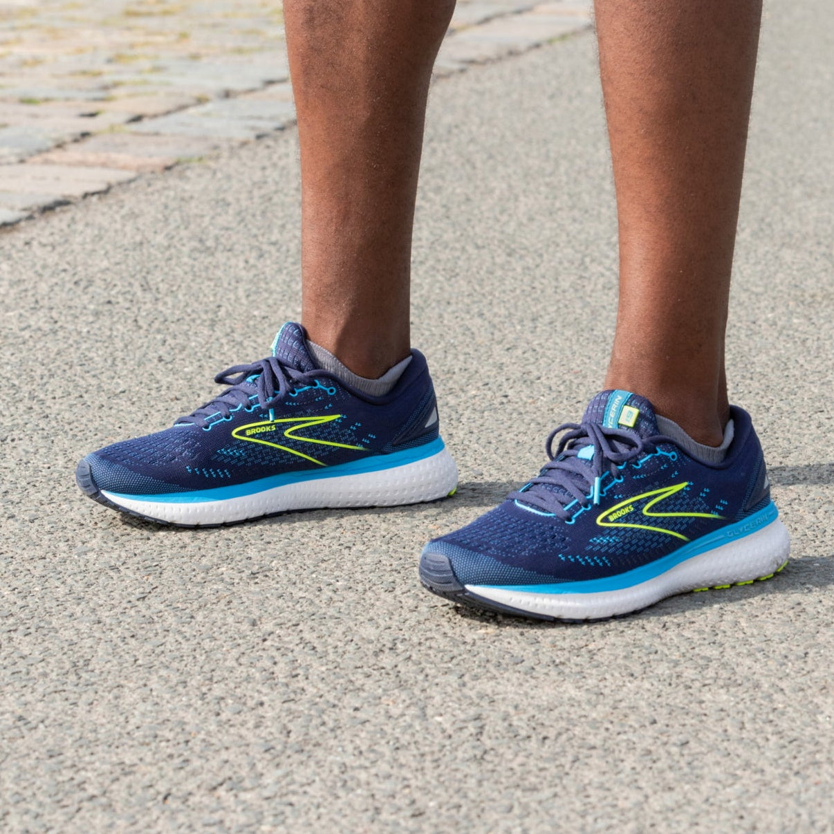 Ein Mann mit dunkelblauen Laufschuhen, nur die Beine sind zu sehen